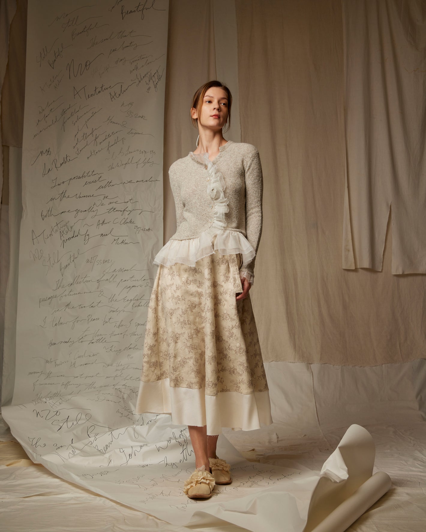 A Tentative Atelier SS23 Lookbook Womens grey knit long sleeve top with tulle ruffle hem and patterned skirt ensemble