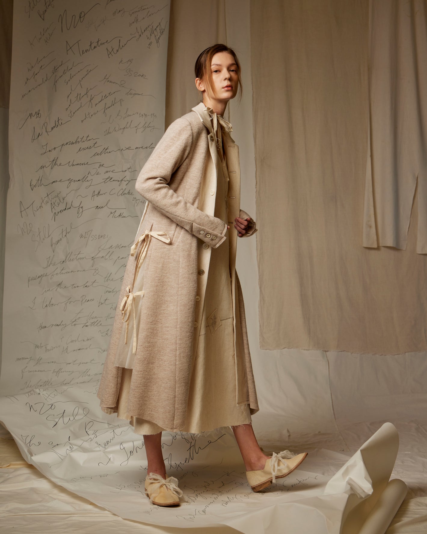 A Tentative Atelier AW22 Lookbook grey coat with side ribbon ties