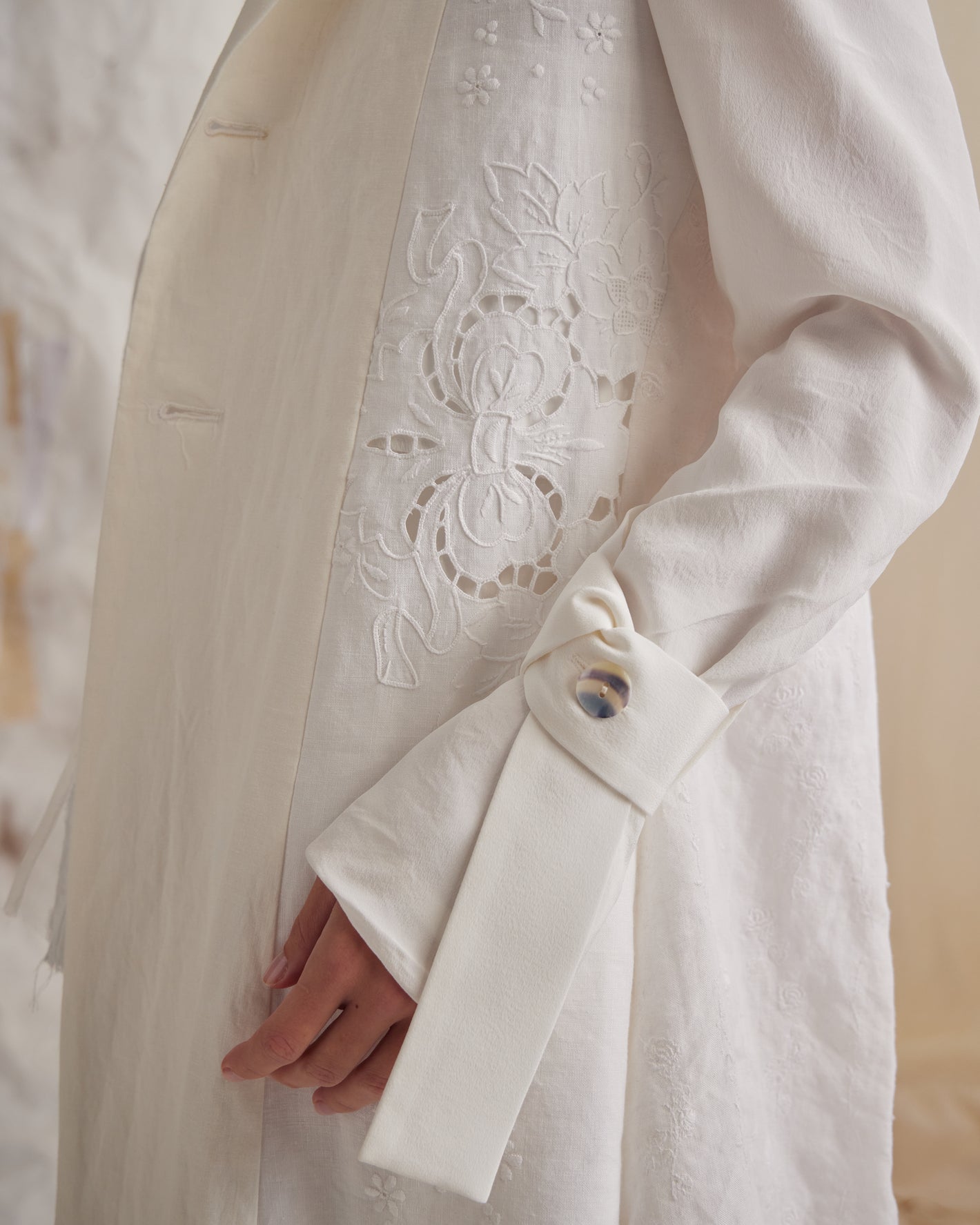 A Tentative Atelier SS23 Lookbook crop of Womens white coat showing the detail of a sleeve