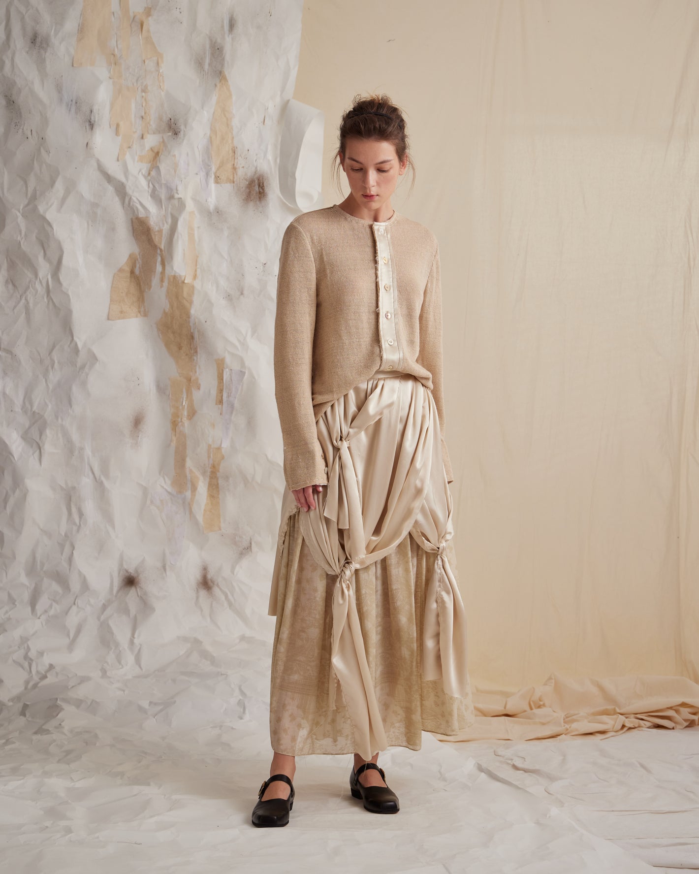 A Tentative Atelier SS23 Lookbook Womens beige cardigan layered on top of a gathered and tied silk dress