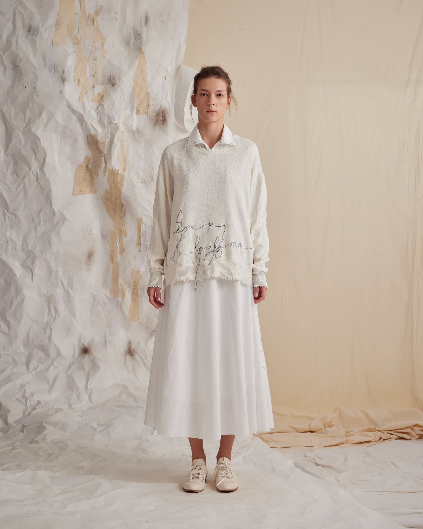 A Tentative Atelier SS23 Lookbook Womens white jumper featuring handwriting embroidery layered over a white long dress