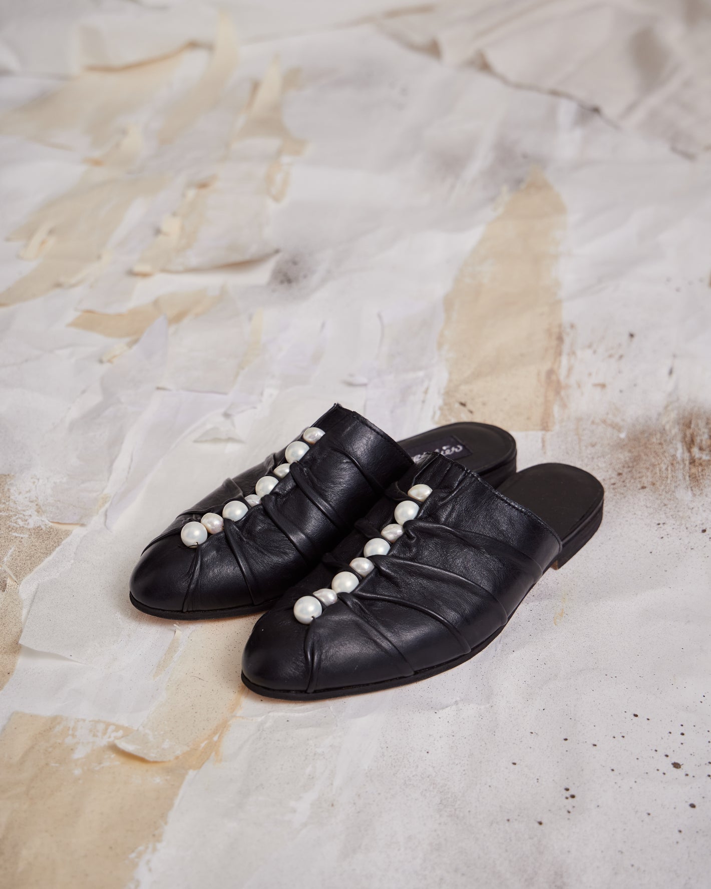 A Tentative Atelier SS23 Lookbook Womens black leather mules with a central row of pearl beads