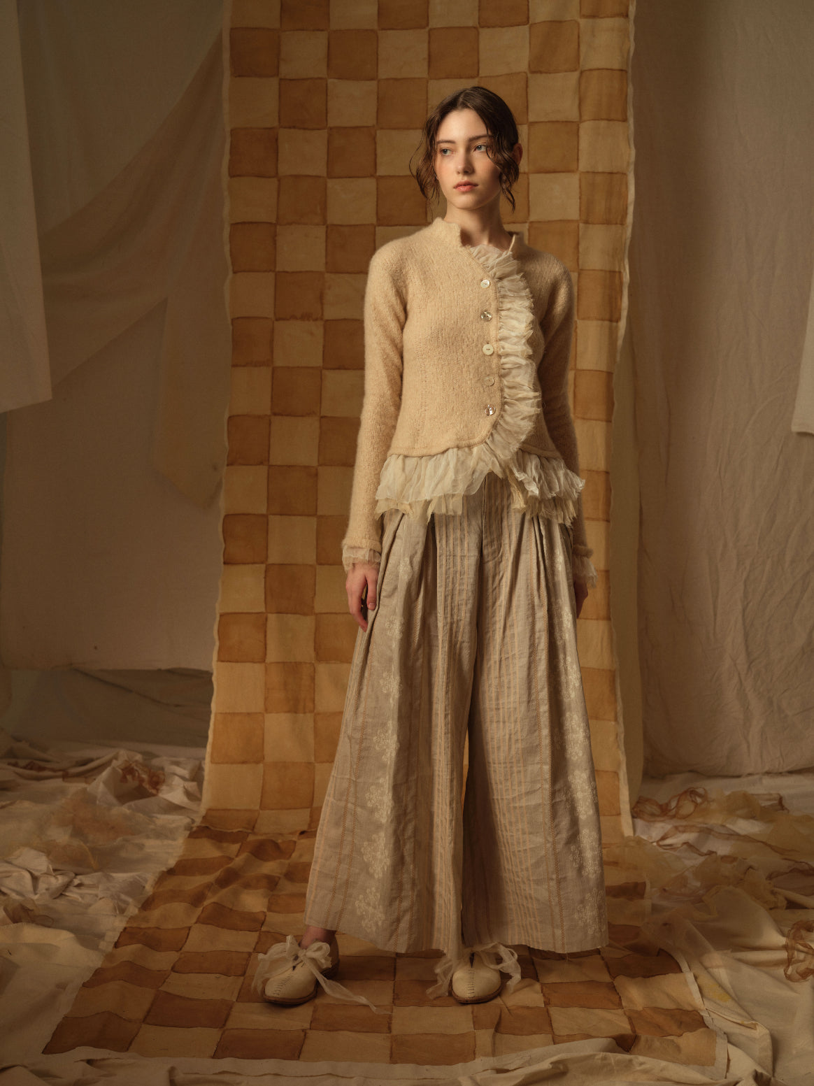 A Tentative Atelier AW21 Lookbook Womens beige tulle ruffle hem cardigan and beige striped wide leg trousers