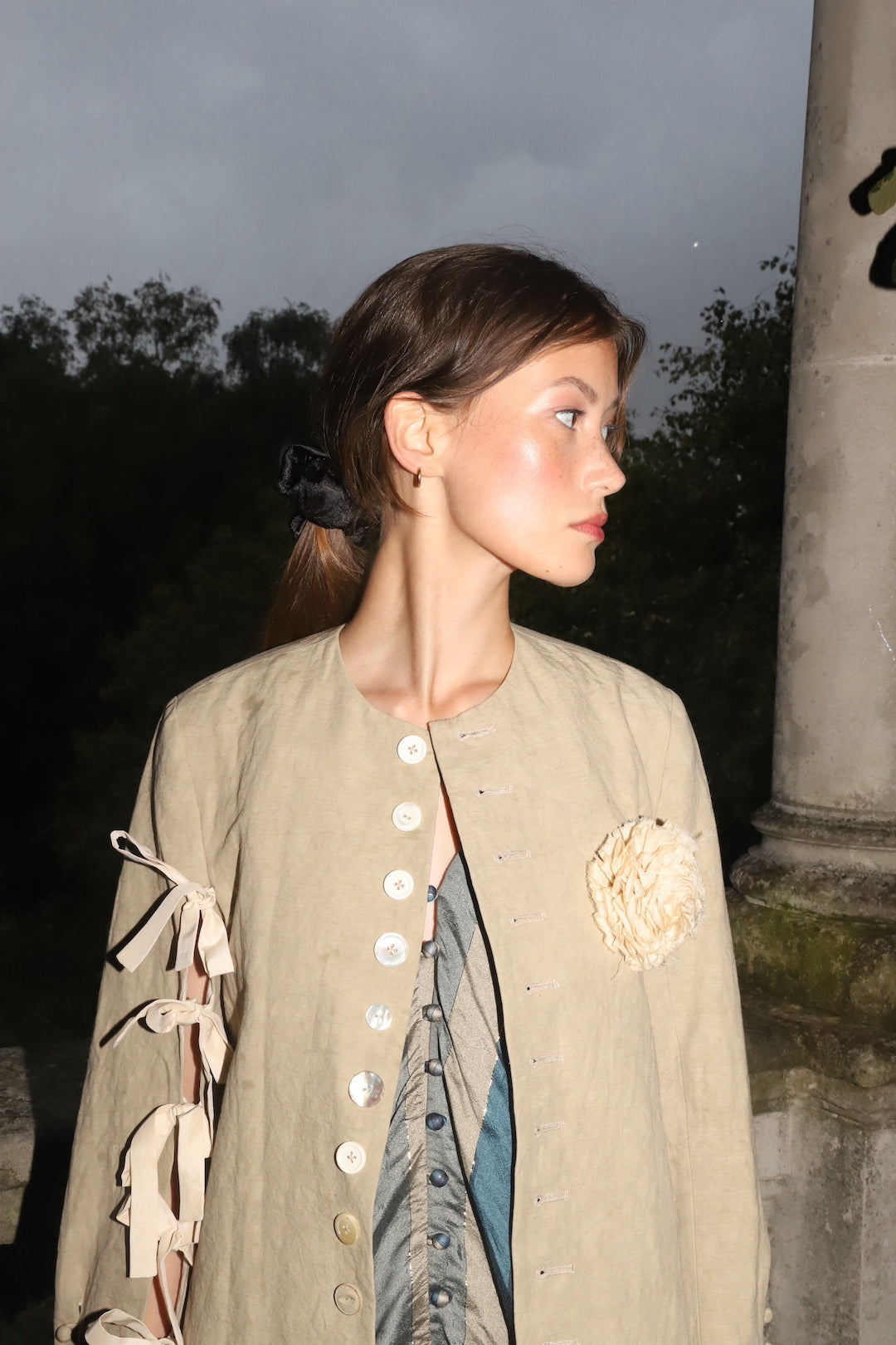 A Tentative Atelier SS24 Lookbook, detail of colarless Womens jacket with a ribbon ties sleeve