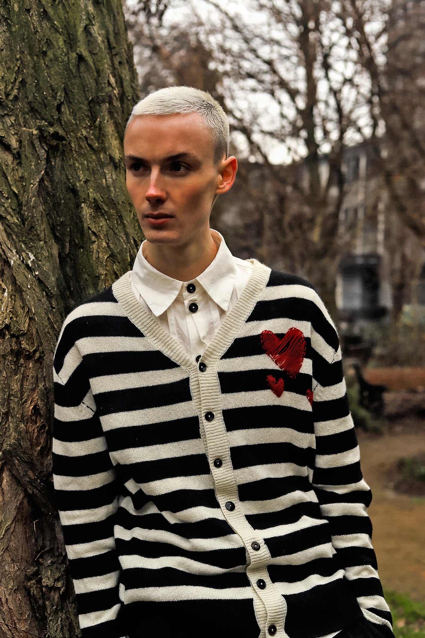 A Tentative Atelier AW23 Lookbook crop of Mens black and white striped cardigan with embroidered hearts on the chest shoulder