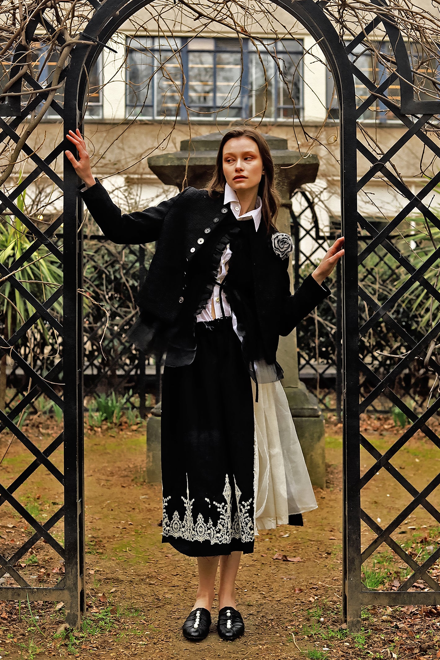 A Tentative Atelier AW23 Lookbook Womens black ruffle jacket and black pleated skirt with an embroidered hem ensemble
