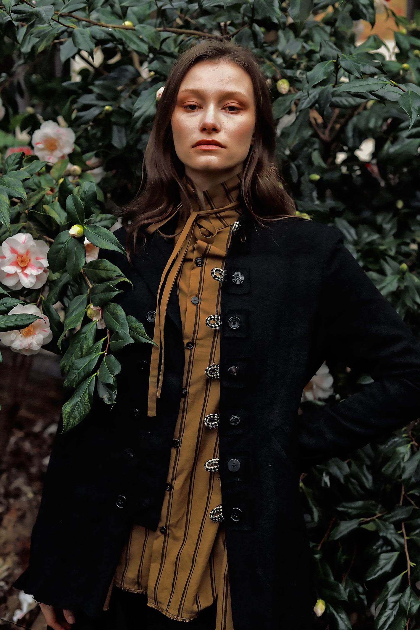 A Tentative Atelier AW23 Lookbook crop of Womens black jacket and brown striped shirt