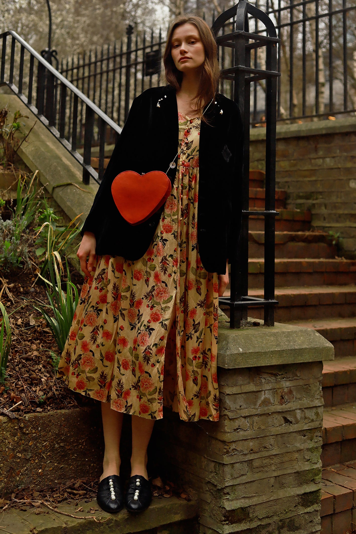 A Tentative Atelier AW23 Lookbook Womens black jacket, floral dress and red heart shaped side body bag ensemble