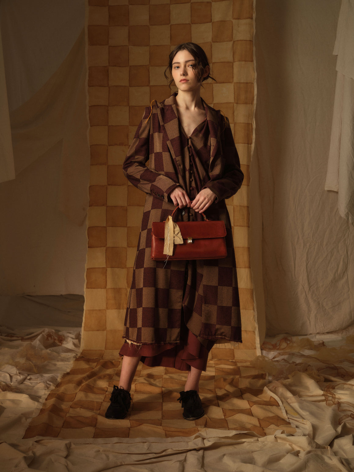 A Tentative Atelier AW21 Lookbook Womens brown checked coat and red leather top handle bag