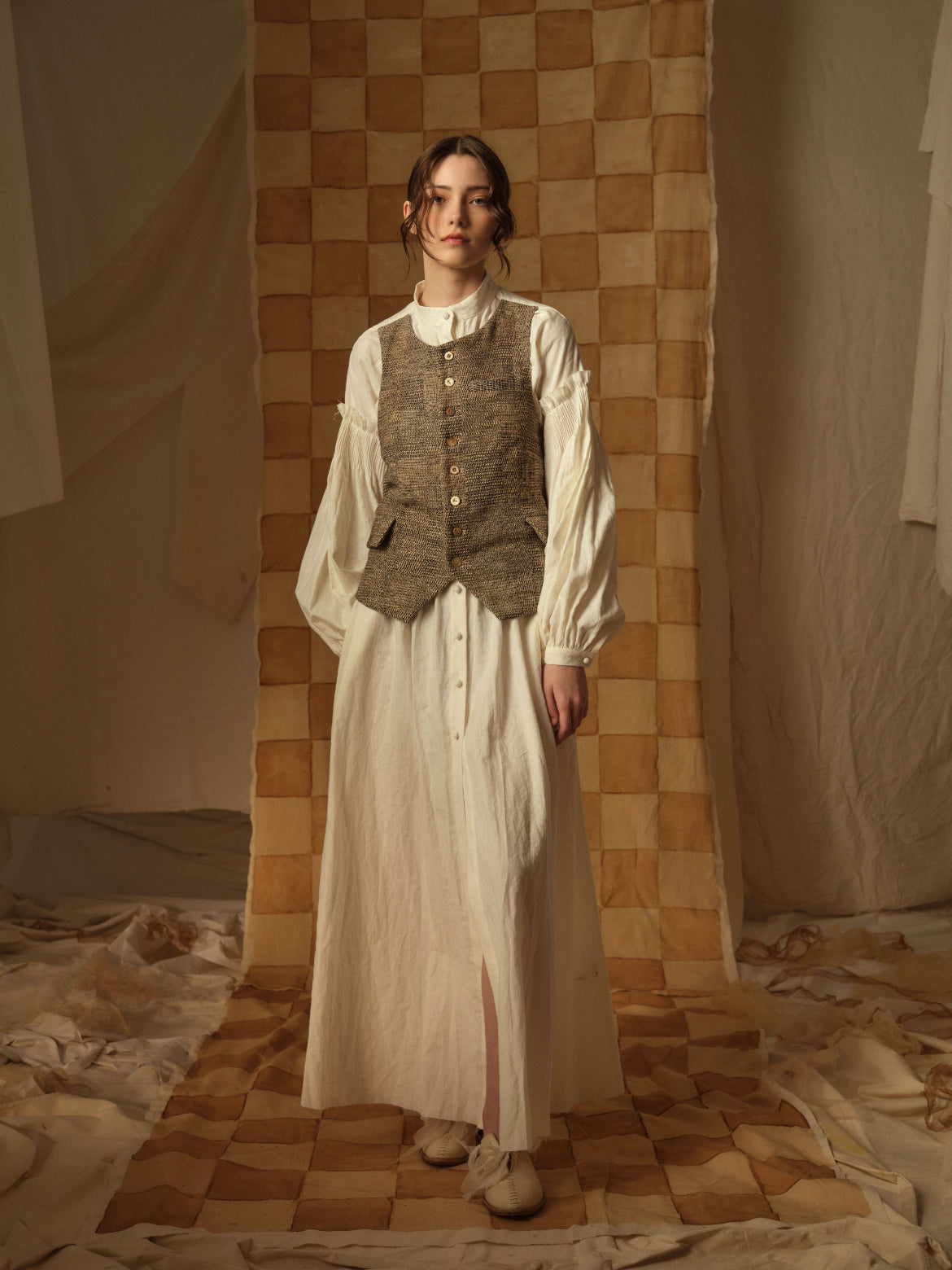 A Tentative Atelier AW21 Lookbook Womens brown buttoned waistcoat and long sleeved cream buttoned dress