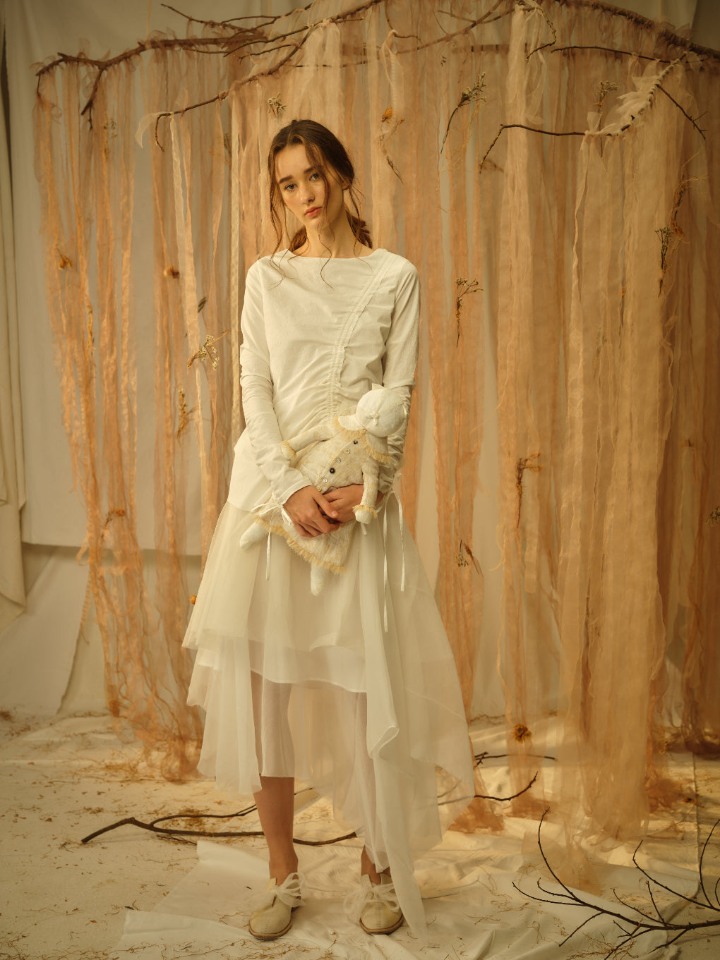 A Tentative Atelier SS21 Lookbook Womens white dress with a ruched top and tulle skirt, and a toy plushie