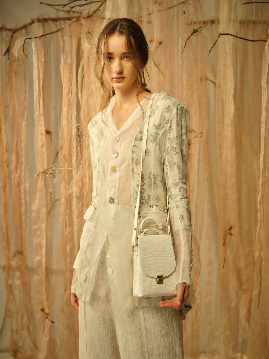 A Tentative Atelier SS21 Lookbook Womens crop of a buttoned shirt jacket with sheer panels and white leather top handle bag