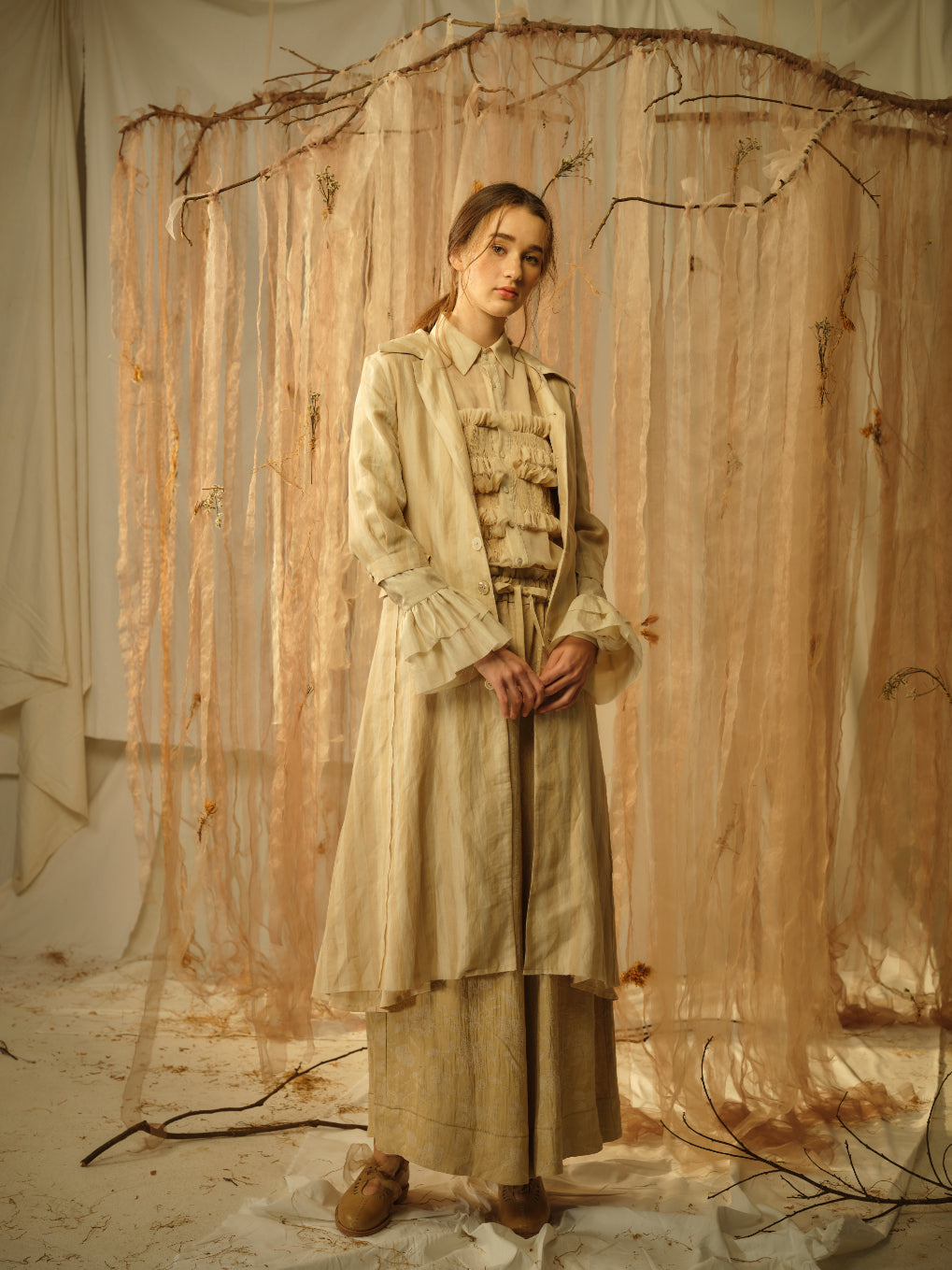 A Tentative Atelier SS21 Lookbook Womens beige bronze coat, ruffle top and brown wide leg trousers