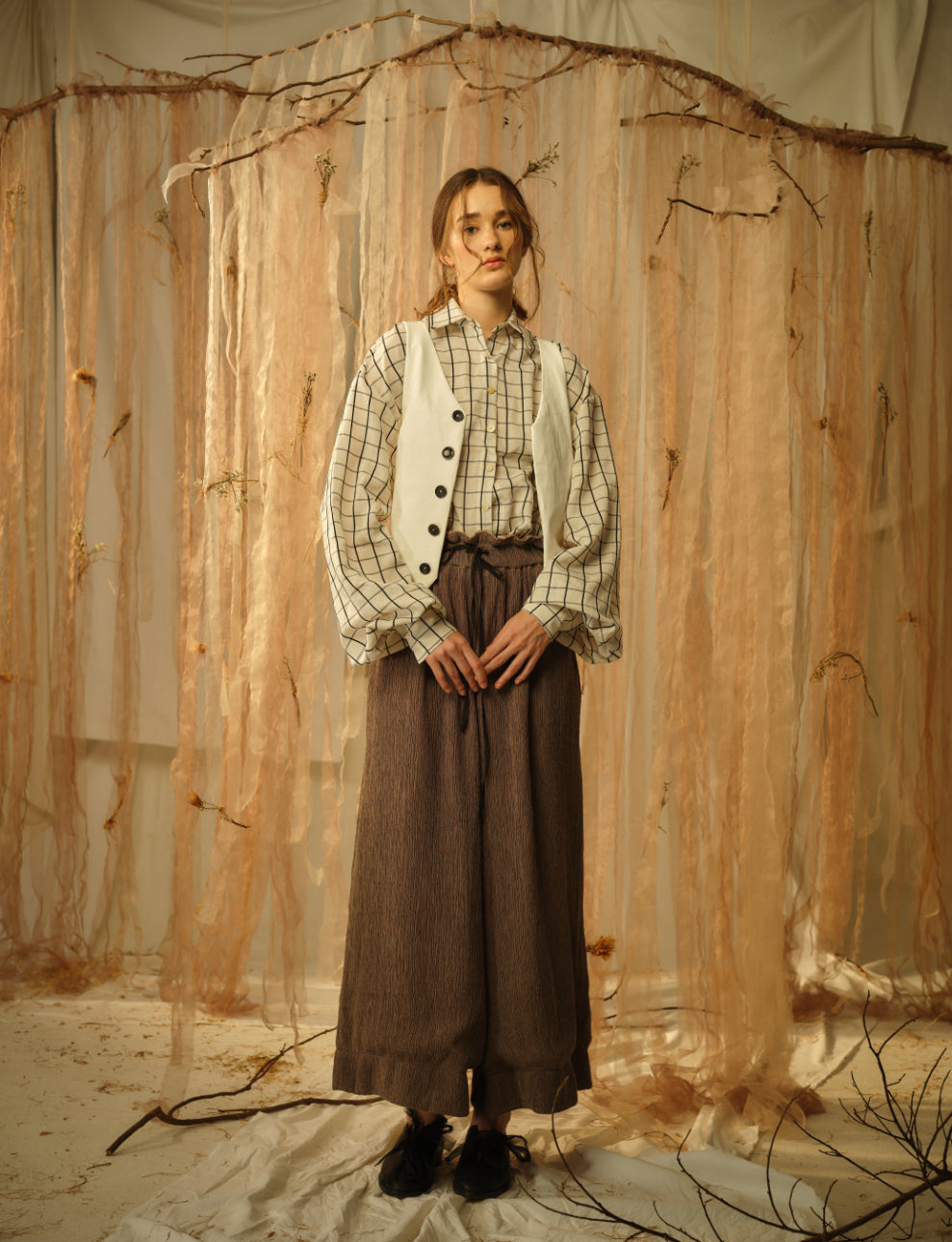 A Tentative Atelier SS21 Lookbook Womens black and white check shirt with a white waistcoat and brown drawstring trousers
