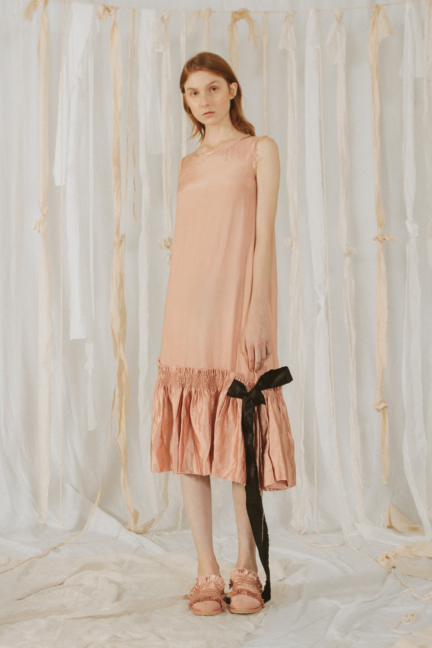 A Tentative Atelier SS18 Lookbook Womens pink sleeveless shift dress with smocked silk hem and black ribbon tie