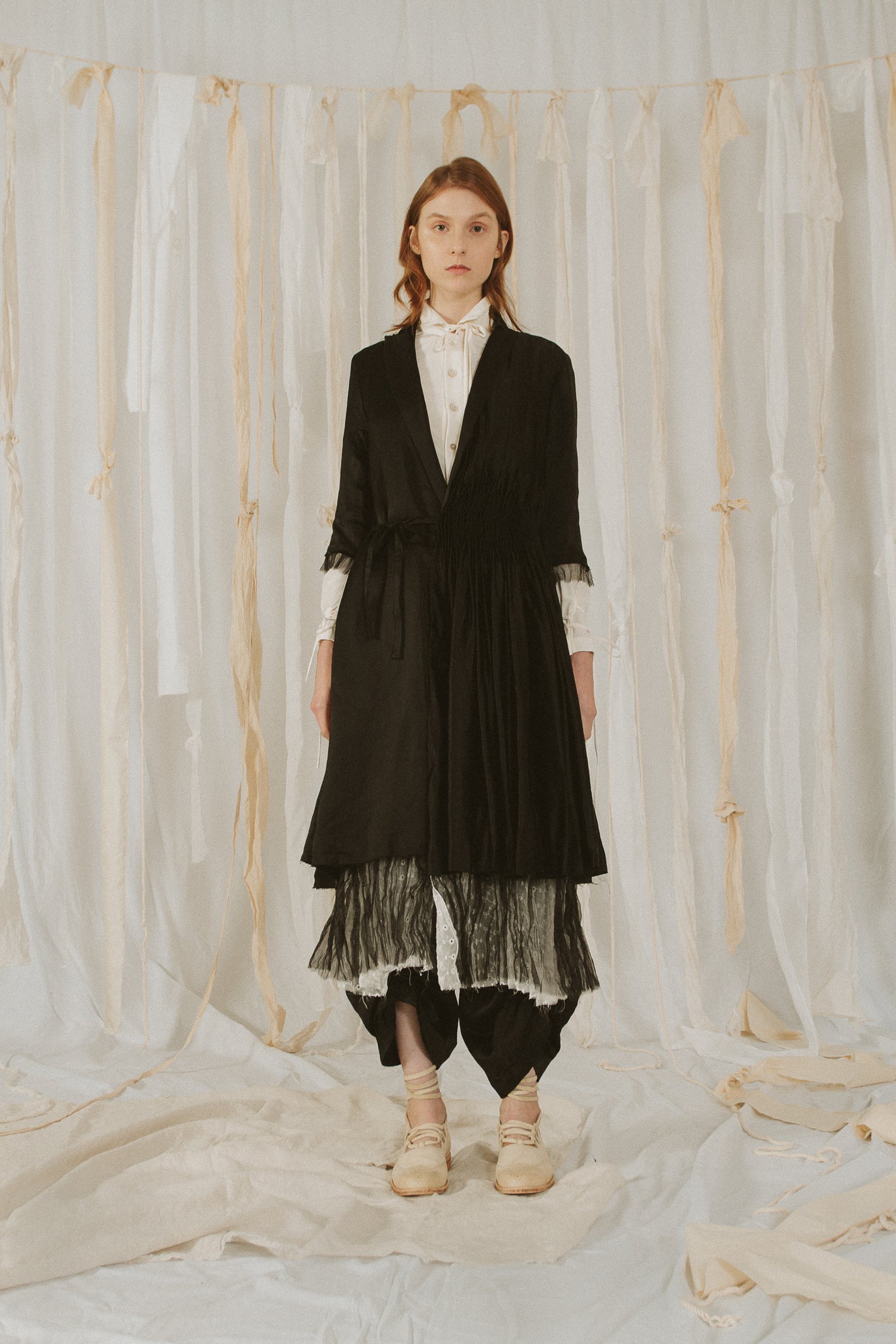 A Tentative Atelier SS18 Lookbook Womens black silk side fastening coat with half length sleeves and black tulle trim