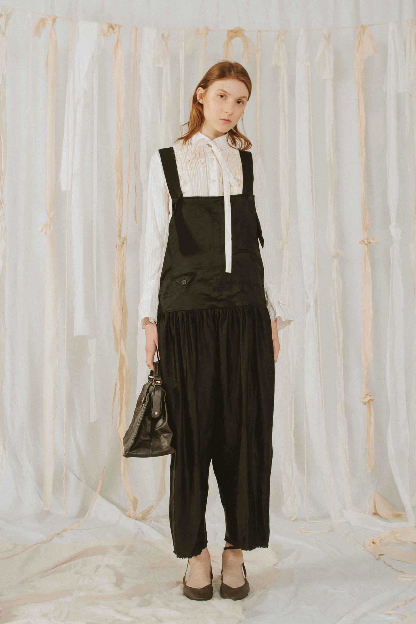 A Tentative Atelier SS18 Lookbook Womens black silk jumpsuit styled with a white blouse and leather bag