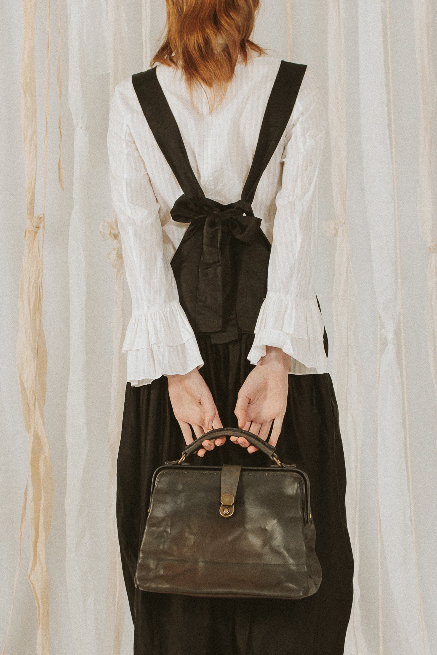 A Tentative Atelier SS18 Lookbook Womens crop of a dark brown leather top handle bag