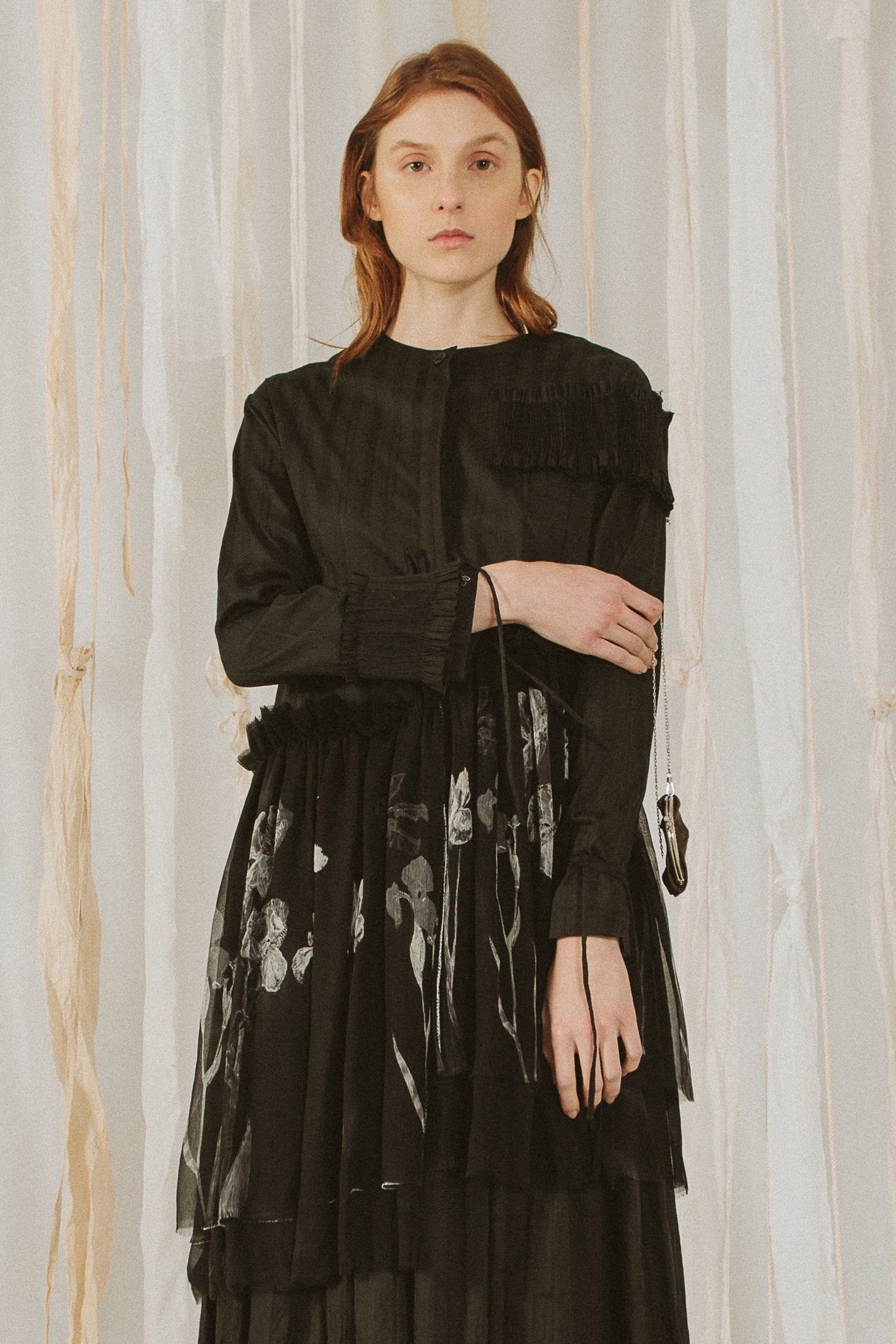 A Tentative Atelier SS18 Lookbook Womens crop of black round neck shirt dress with printed black cloth appliqué at the waist, styled with a mini black leather chain purse