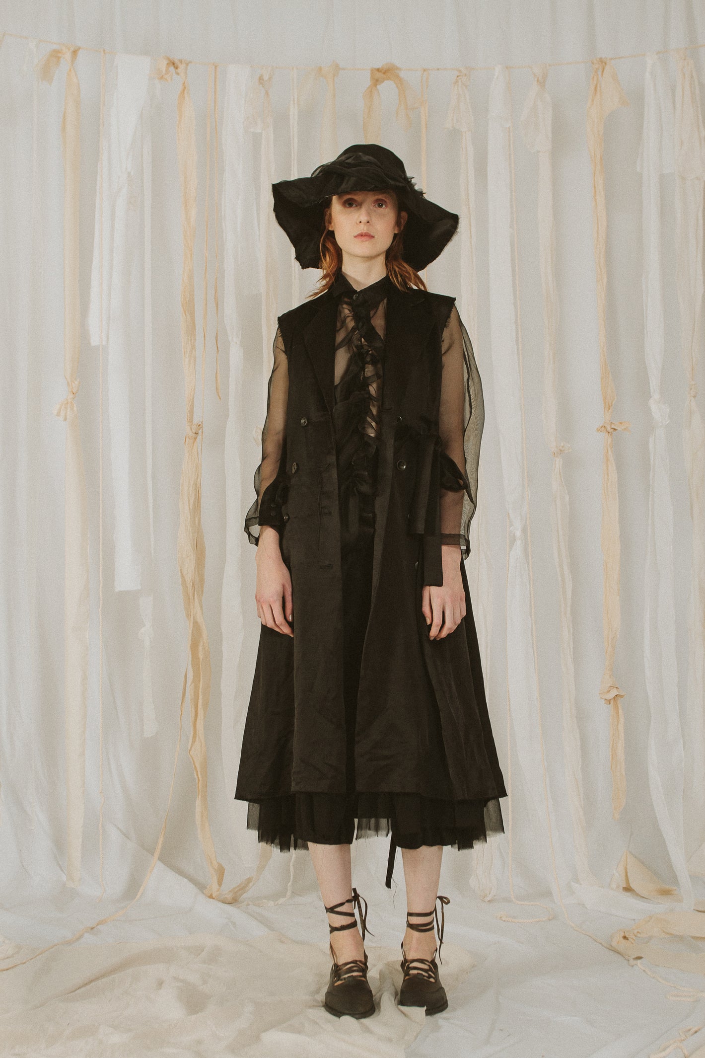 A Tentative Atelier SS18 Lookbook Womens black silk coat with sheer sleeves, styled with a broad rim black hat