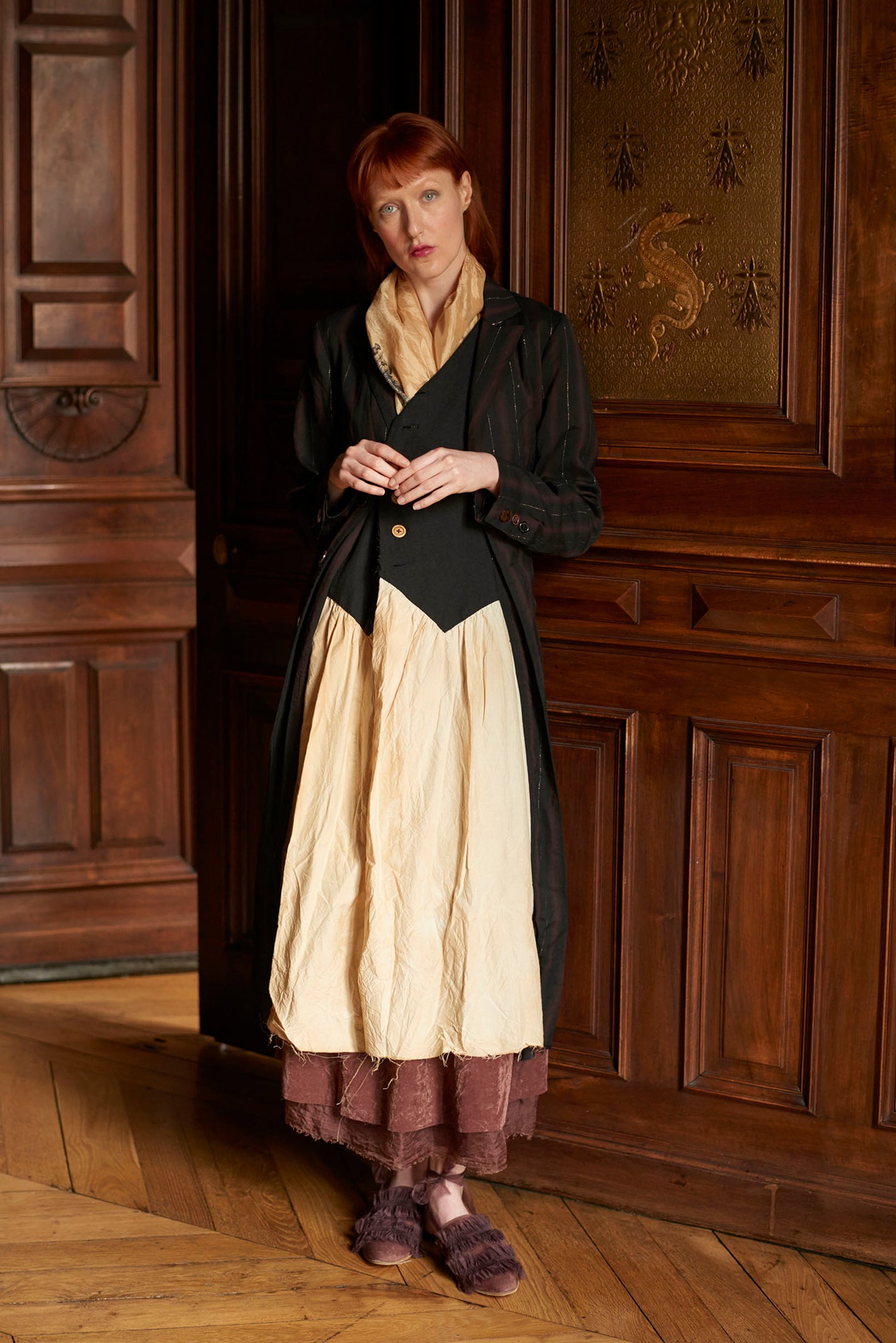 A Tentative Atelier AW20 Lookbook Womens layered look featuring a black striped coat, monochrome dress and red velvet hem