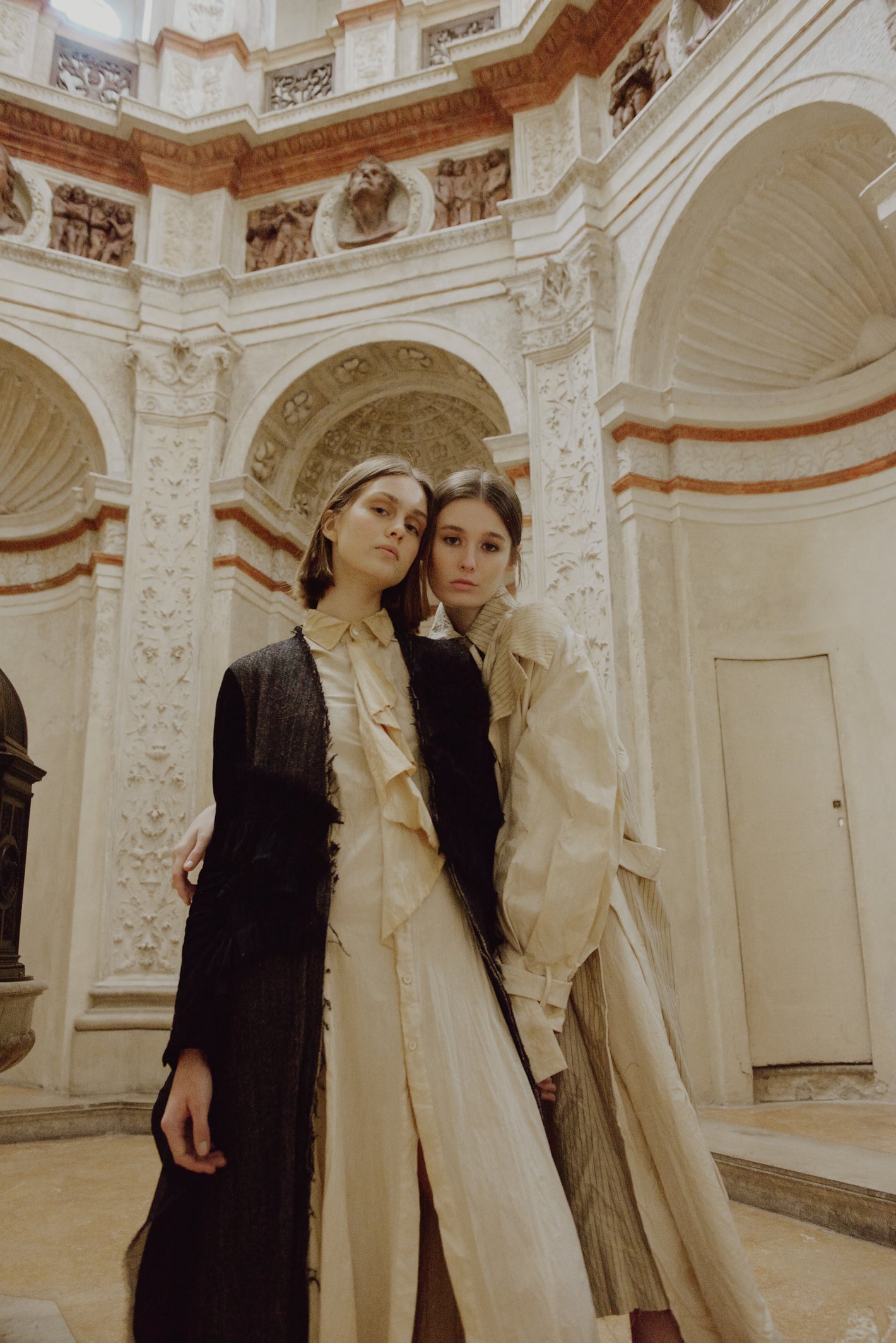 A Tentative Atelier AW19 Lookbook Womens crop of two models, one pictured with a black coat and the other a white coat