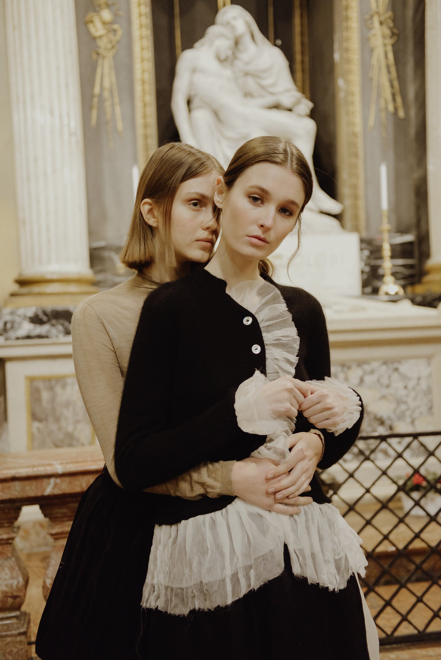 A Tentative Atelier AW19 Lookbook Womens two models, the one in the foreground pictured wearing a black cardigan with white tulle ruffle trim 2