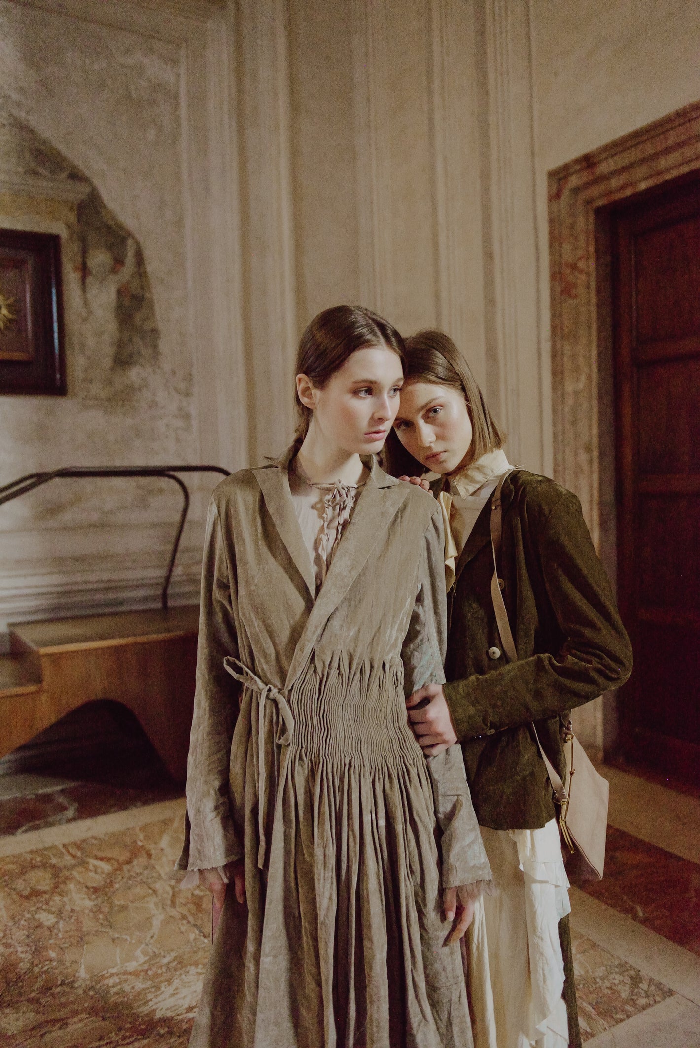 A Tentative Atelier AW19 Lookbook Womens crop of two models, pictured wearing a brown smocked waist coat and moss green brown jacket respectively