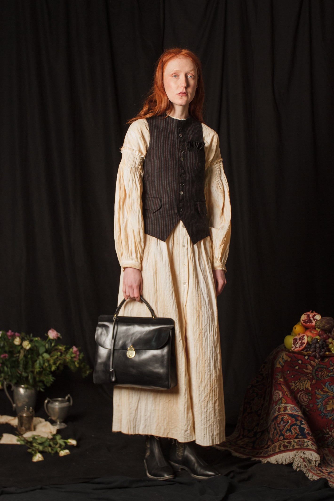 A Tentative Atelier AW18 Lookbook Womens brown striped waistcoat and off white striped and crinkled long sleeve dress, style with a black leather top handle bag