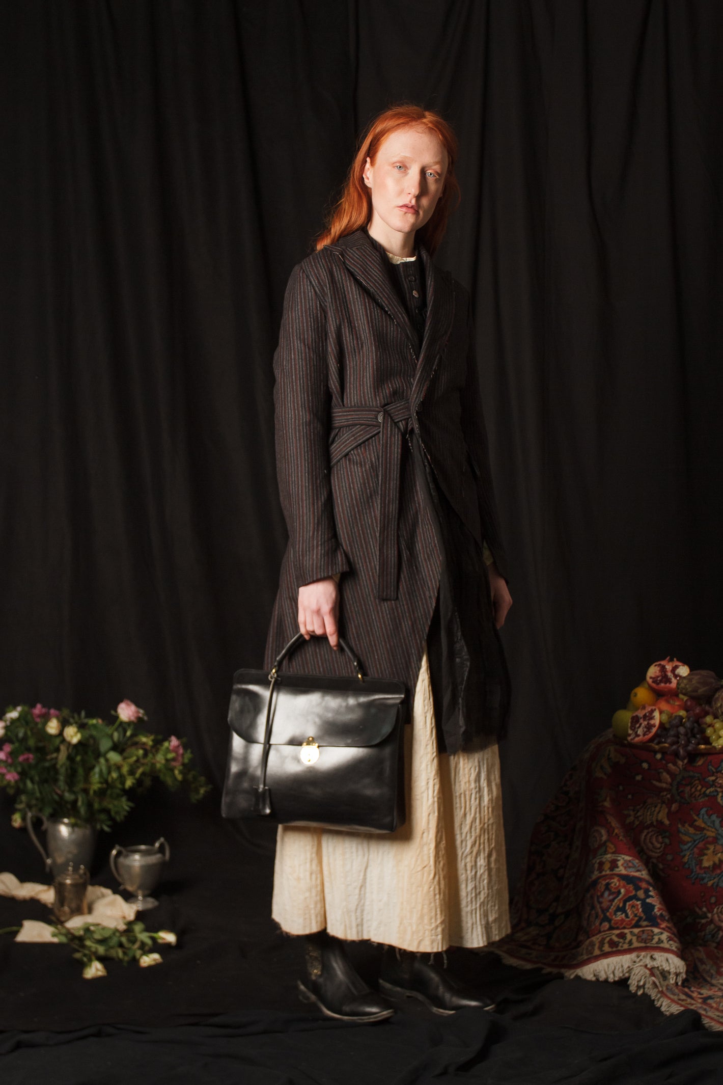 A Tentative Atelier AW18 Lookbook Womens black striped side fastening coat and black leather top handle briefcase bag
