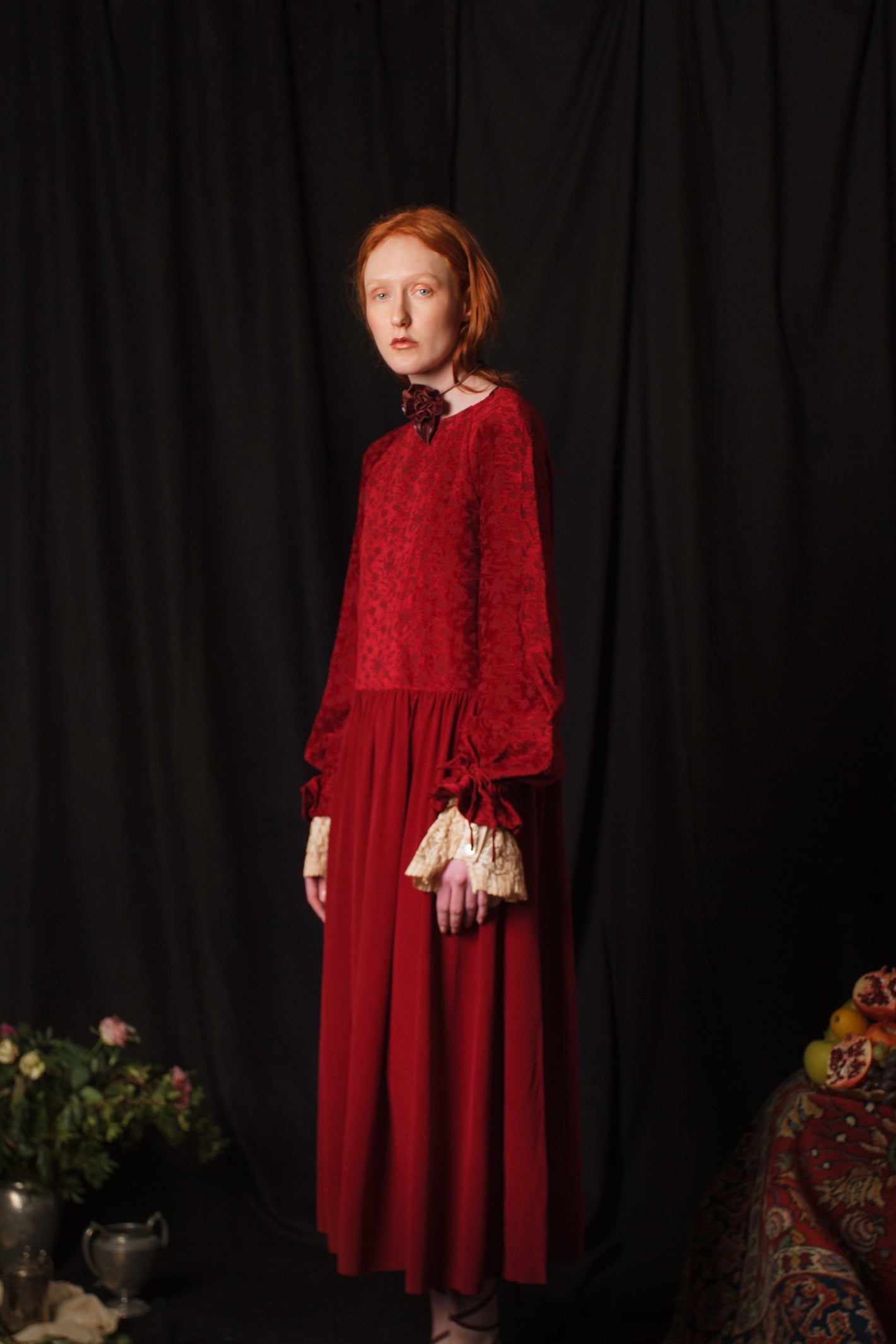 A Tentative Atelier AW18 Lookbook Womens crop of a red dress with a velvet top and ribbon ties gathered sleeves with contrasting lace cuffs