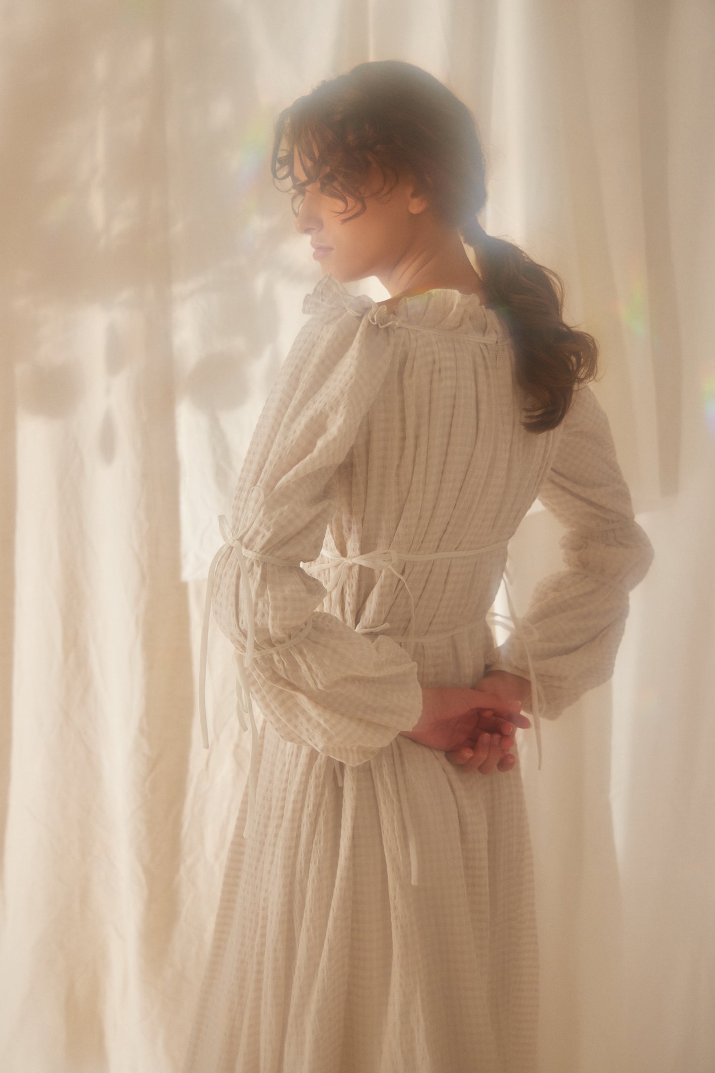 A Tentative Atelier SS22 Lookbook crop of the back of a ruffle neckline gingham dress