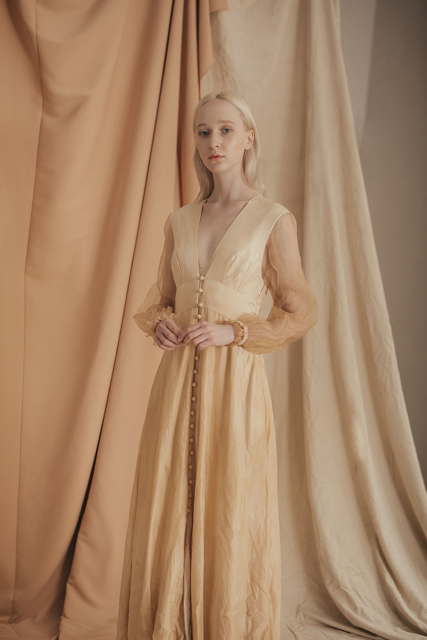 A Tentative Atelier SS20 Lookbook Womens crop of beige v-neck dress with buttons and sheer sleeves