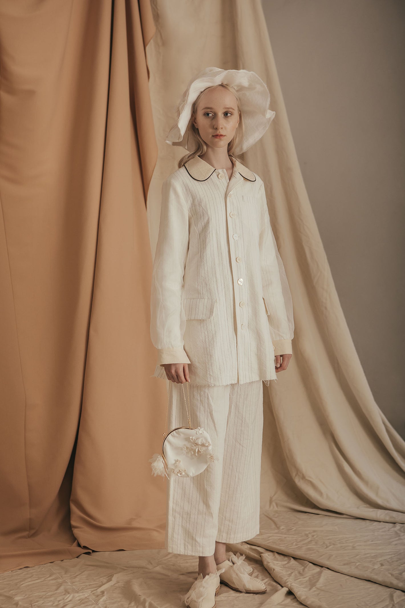 A Tentative Atelier SS20 Lookbook Womens white striped round collar jacket and trousers, white bonnet, and white round chain bag