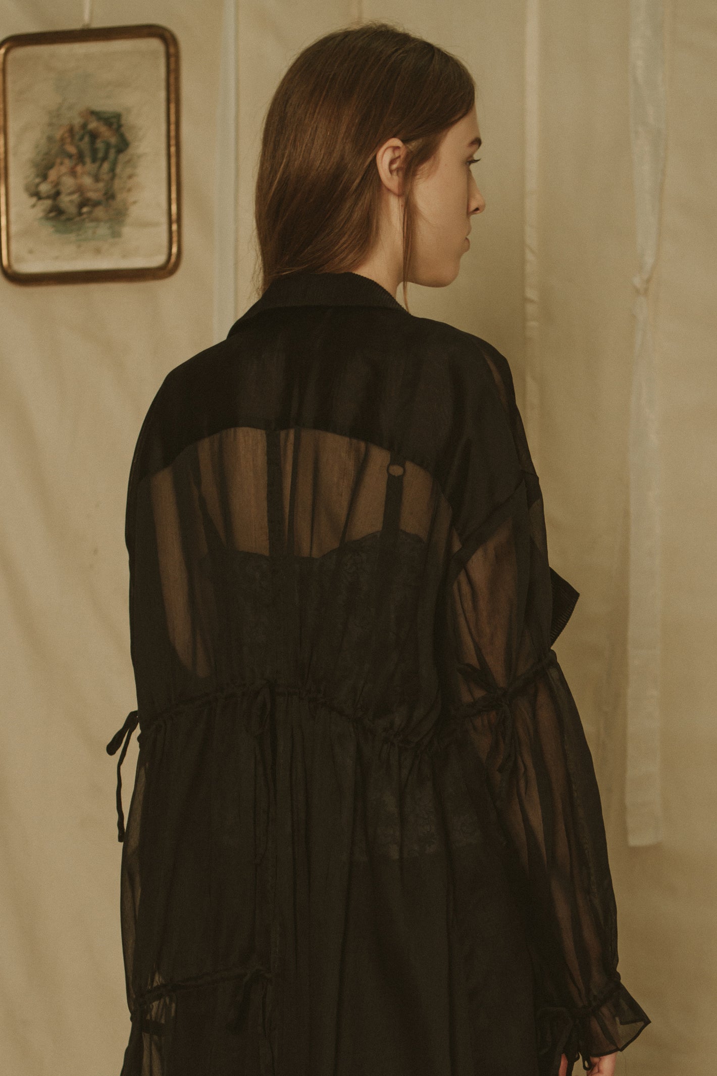 A Tentative Atelier SS19 Lookbook Womens crop of the back of a black sheer coat with a gathered waist and gathered sleeves
